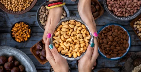 Zwei Personen halten eine Schale mit Cashewnüssen.