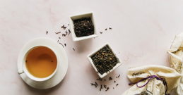 Evas Kräutertee am Tisch mit Kräuter in kleinen  schelchen