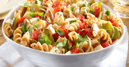 Nudelsalat in einer Schüssel mit Gurke, Tomate & Feta-Käse