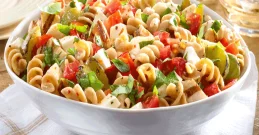 Nudelsalat in einer Schüssel mit Gurke, Tomate & Feta-Käse