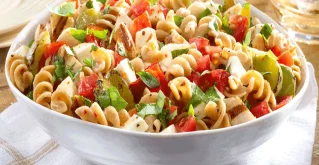 Nudelsalat in einer Schüssel mit Gurke, Tomate & Feta-Käse