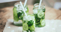Gurkenwasser mit Minzeblättchen im Glas mit Strohhalm.