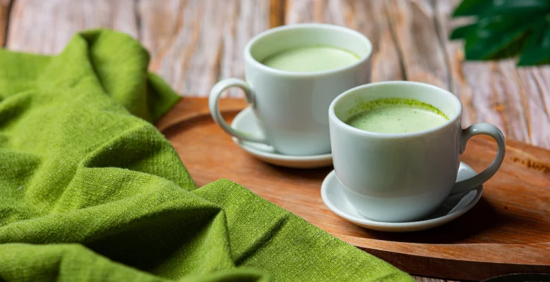 Zwei Tassen Matcha am Holz Tisch