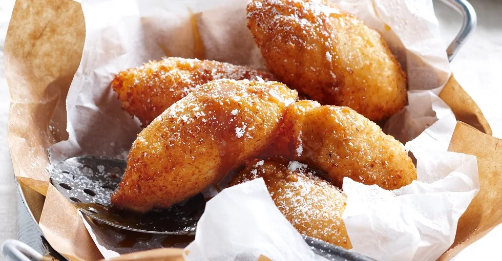 Luftige, frittierte Teigbällchen mit Banane am Teller