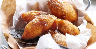 Luftige, frittierte Teigbällchen mit Banane am Teller