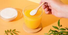 Natriumascorbat in Pulver Form und ein Glas mit Saft